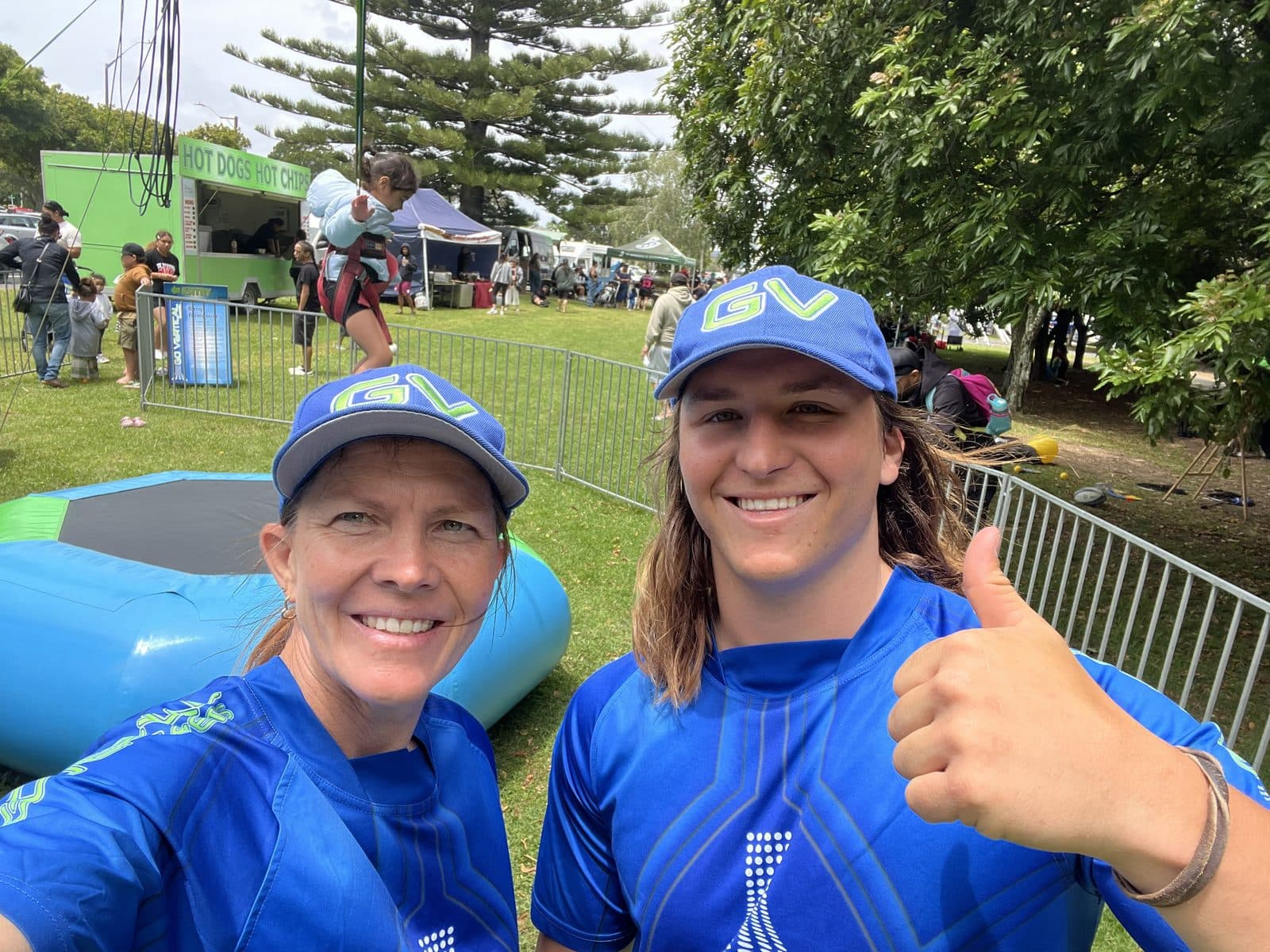Two Go Vertical crew members in branded shirts and caps at a community event