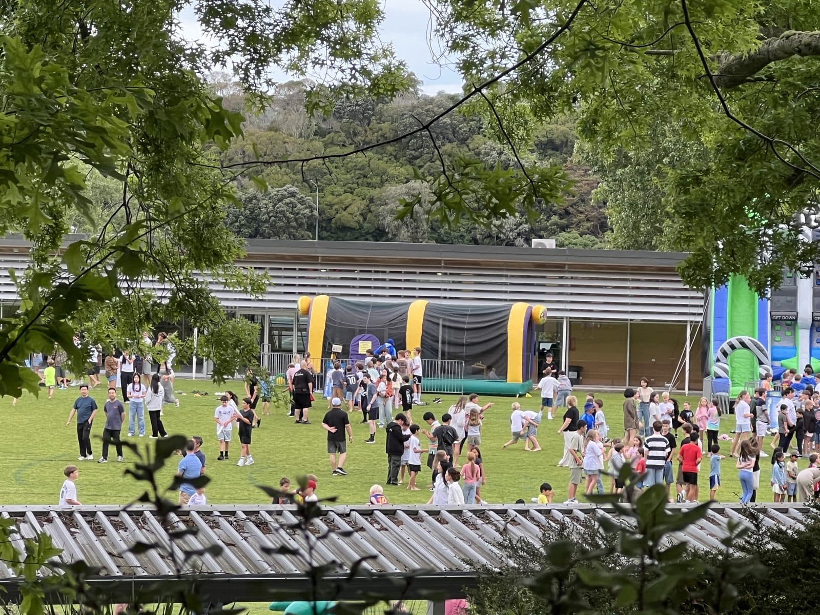 A Go Vertical school event — inflatables set up on a field with hundreds of students